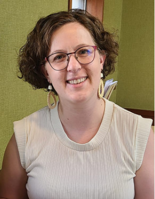 Photo of Danna Bergantine, a white woman in her 30s with short, curly hair and glasses. 